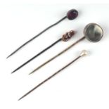 Four late Victorian / Edwardian stick pins to include a natural pearl finial example (4).