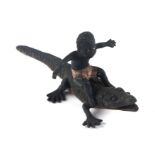 An antique novelty Vienna cold painted bronze miniature depicting a black boy ridding a crocodile,