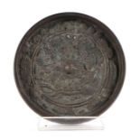 A Chinese bronze circular mirror, 11.5cms diameter.