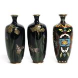 A pair of Japanese cloisonne vases decorated with irises on a midnight blue ground, 15cms high;