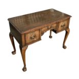 A George II style walnut side table with moulded rectangular top above an arrangement of three