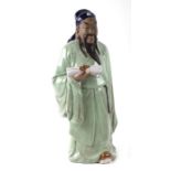 A large Chinese pottery figure of a scholar holding a scroll, 47cms high.