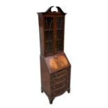 A Georgian style mahogany bureau bookcase of slender proportions, the pair of glazed doors enclosing