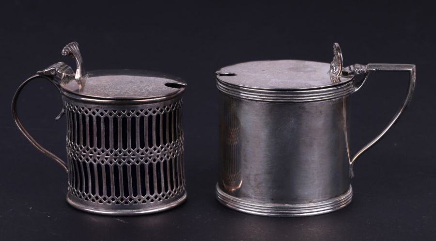 A silver mustard pot with blue glass liner, London 1923; together with another silver mustard pot,