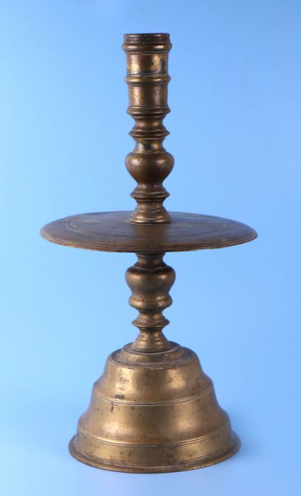 A 17th / 18th century Dutch bell bottom candlestick with ring turned column above a large circular