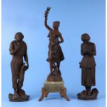 A pair of French spelter figures depicting peasants; together with another similar on a green marble