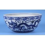 A Chinese blue & white bowl decorated with dragons amongst clouds, 27cms diameter.