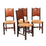 A set of four dining chairs with leather backs and rush seats.