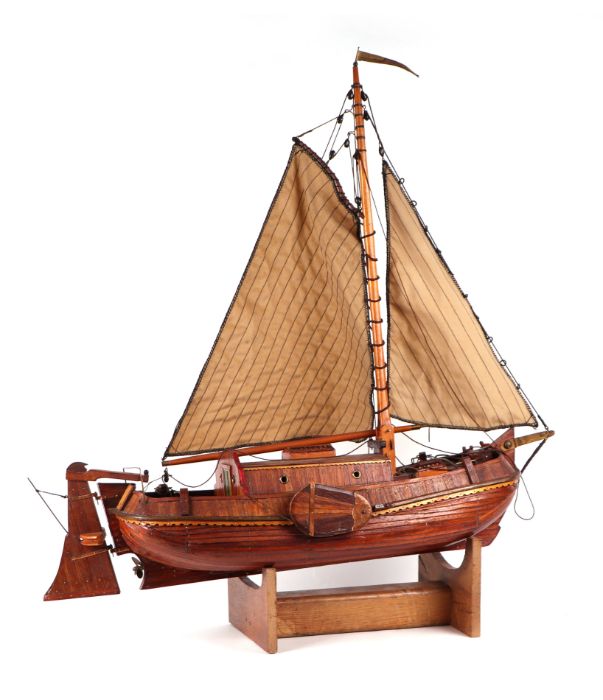 A scratch built model of a single masted boat, on stand, 77cms long.