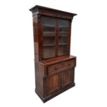 An early 19th century flame mahogany secretaire bookcase, the pair of glazed doors enclosing a
