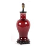 A Chinese sang de boeuf baluster vase converted to a table lamp on a carved hardwood stand, 33cms