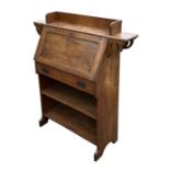 An Art Nouveau oak students bureau with three-quarter galleried shelf above a fall-front,