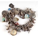 A silver padlock charm bracelet with approx 30 charms to include a compass, tankard, enamel shield