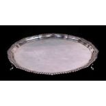 A silver salver with shaped edge, on three feet, Birmingham 1924, 32cms diameter, 888g.