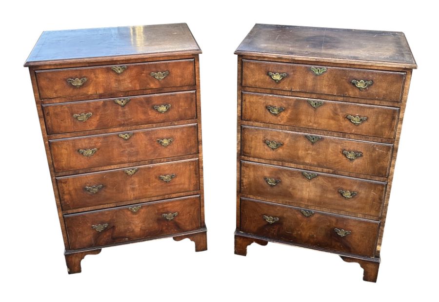 A pair of George III style mahogany chests, each with an arrangement of five long drawers, on