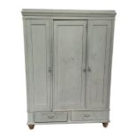 A continental painted pine triple wardrobe, the moulded cornice above three panelled doors and one