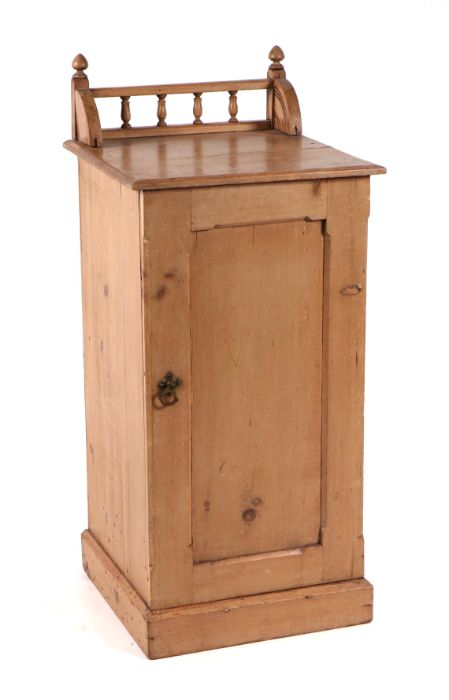 A pine pot cupboard with galleried back above a single panelled door enclosing a shelved interior,