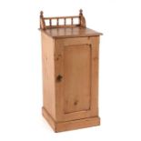 A pine pot cupboard with galleried back above a single panelled door enclosing a shelved interior,