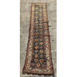 A Persian hand knotted runner, the central medallions on a blue ground within a multi border, 419 by