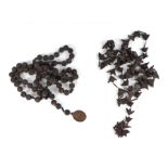 A Chinese 'bat nut' rosary; together with another Chinese carved nut rosary with brass pendant dated