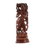 A large Indian hardwood figure depicting Krishna playing a flute, 34cms high.