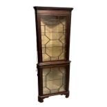 A mahogany corner display cabinet, the pair of astragal glazed doors enclosing a shelved interior,