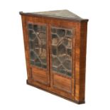 A 19th century mahogany hanging corner cabinet, the pair of astragal glazed doors enclosing a