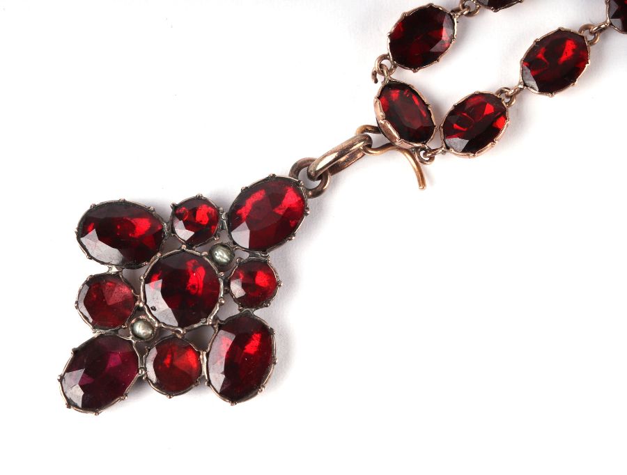 An early 19th century yellow metal mounted garnet riviere pendant drop necklace. - Image 2 of 2