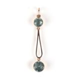 A yellow metal mounted pendant set with two pale blue stones, possibly aquamarine.Condition