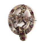 A Victorian white metal Scottish type brooch surmounted with a medieval knight on horseback within a