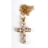 A delicate 9ct gold gem set cross on a fine chain.