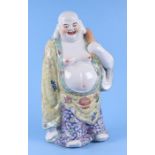 A Chinese famille rose Buddha figure carrying a sack over his shoulder, impressed five character