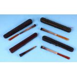 A group of cased cigarette holders with amber like mouthpieces (a/f).