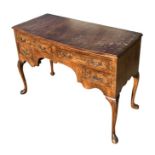 A George II style walnut bowfront crossbanded side table with an arrangement of four drawers, on