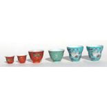 A pair of Chinese tea cups decorated with flowers, birds and calligraphy, on a turquoise ground,