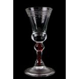 An 18th century wine glass with engraved trumpet bowl, spiral air twist knopped stem and conical