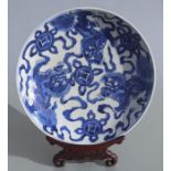 A Chinese blue & white charger decorated with temple lions, on a pierced hardwood stand, 35cms