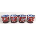 A set of four Japanese Arita octagonal beakers decorated with figures of Nambam people, on