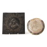 A bronze plaque depicting a bust portrait of Christ within a starburst, 15cms wide; together with