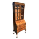 A 1930's walnut bureau bookcase, the upper section with a caddy top above two astragal glazed