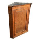 A 19th century mahogany corner cupboard, the single door with inlaid shell decoration, 86cms wide.