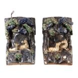A pair of Chinese glazed Shiwan pottery wall pockets decorated in relief with donkeys and birds,