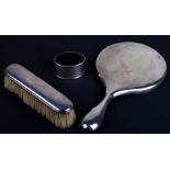 A silver backed dressing table hand mirror, London 1913; together with a silver backed hairbrush,