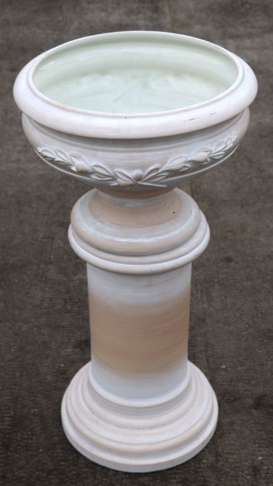 A pottery planter on column stand.