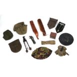 A quantity of assorted military field items to include a cased shovel, ammunition belts and other