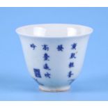 A Chinese blue & white tea bowl decorated with rocks and calligraphy, 5.5cms high.