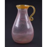 A Venetian pink glass water jug with free form yellow glass handle and rim, 23cms high.