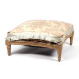 A 19th century painted pine square footstool with swept sides and sprung upholstered top, 68cms