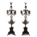 A pair of Bardienne style bronze four-branch candelabra with griffin form candle snuffers, on