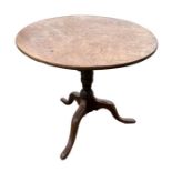 A 19th century elm tripod table with turned column terminating on a tripod base with slipper feet,